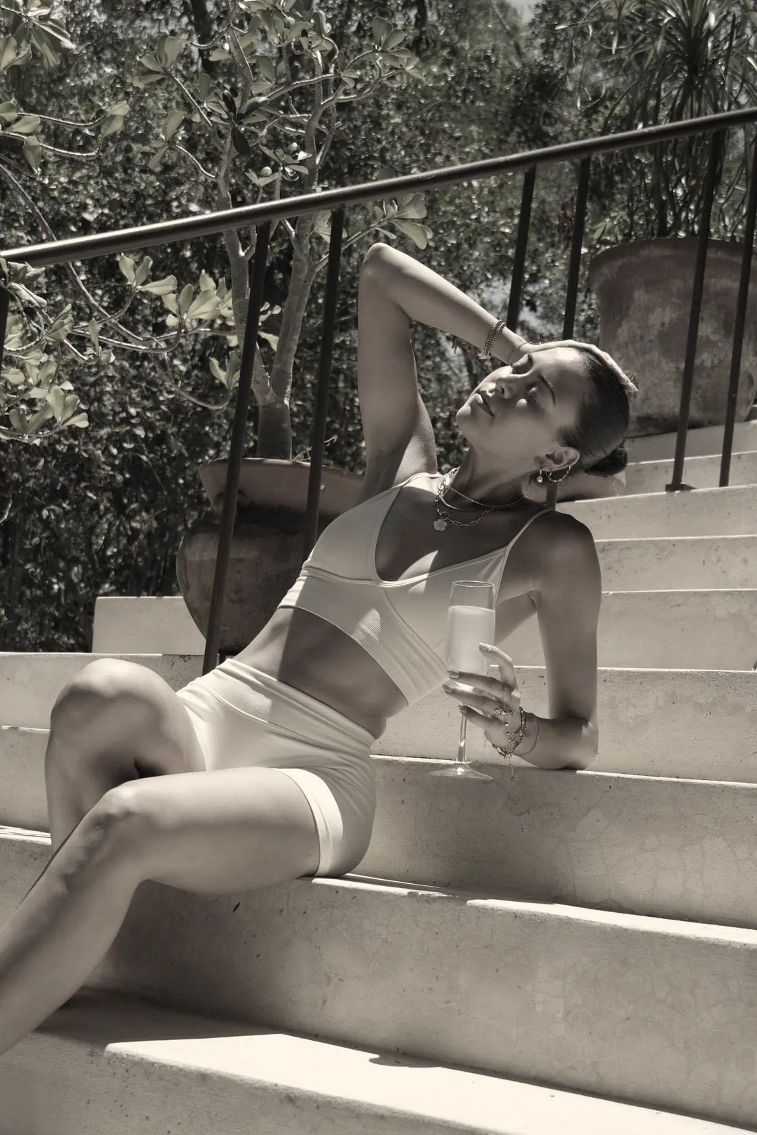 A woman relaxing on stone steps with a glass